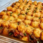Mexican tater tot casserole with seasoned beef, cheese, beans, and crispy tots