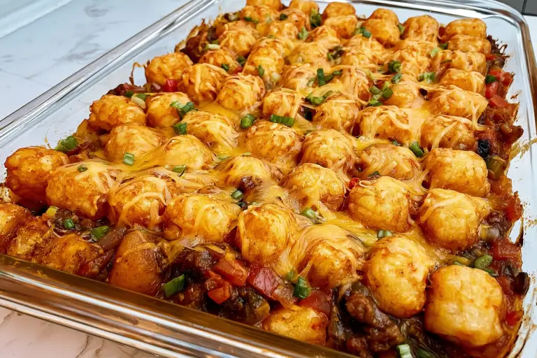 Mexican tater tot casserole with seasoned beef, cheese, beans, and crispy tots