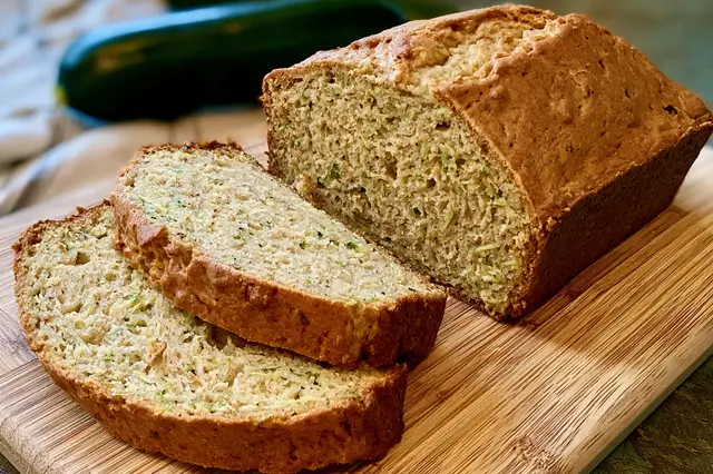 Freshly baked loaf of Greek yogurt zucchini bread sliced on a cooling rack.