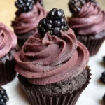 Decadent Midnight Blackberry Chocolate Cupcake topped with rich dark chocolate ganache and fresh blackberries.