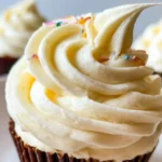 Fluffy white vanilla pudding frosting topped with sweet coconut flakes and colorful sprinkles.