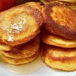Golden fried cornbread Southern cornmeal hoecakes stacked on a plate ready to serve.