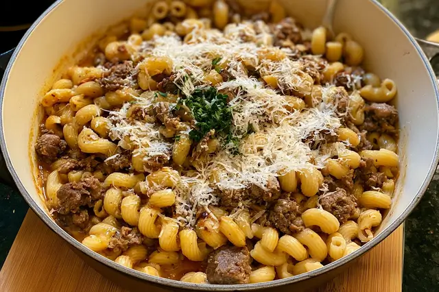 One-pot cheesy beef and garlic butter pasta topped with melted cheddar and fresh parsley.