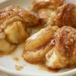 Peeled apple halves wrapped in biscuit dough and baked in sweet cinnamon sauce