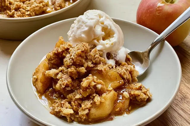 Sliced cinnamon-spiced apples baked under a crunchy oat and brown sugar crumble topping