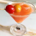 Savory chilled tomato martini garnished with an olive, cherry tomato, and cocktail onion.