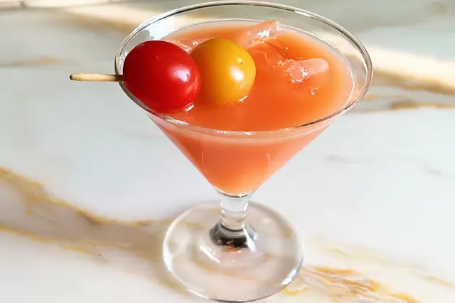 Savory chilled tomato martini garnished with an olive, cherry tomato, and cocktail onion.