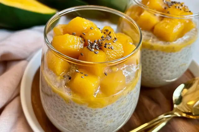 Creamy mango chia seed pudding served chilled in a glass garnished with fresh mango slices and mint leaves.