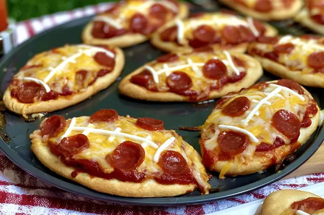 Mini football-shaped pizzas topped with pizza sauce, melted mozzarella, and savory pepperoni.