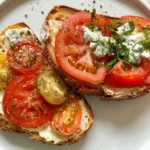 Tomato Picnic Toast with Blue Cheese Mayo: A Flavor Burst! 5 Toasted sourdough slice spread with blue cheese mayo and topped with sliced heirloom tomatoes and chives.