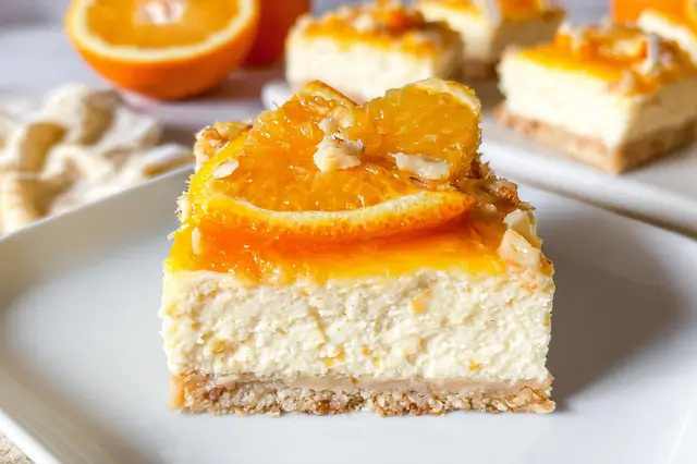 Vibrant orange creamsicle cheesecake bars baked in a buttery graham cracker crust.