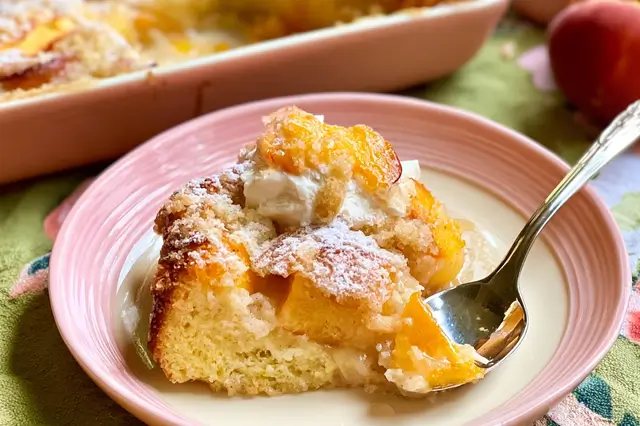 Freshly baked peach spoon cake with sliced peaches, lemon zest, and vanilla bean.
