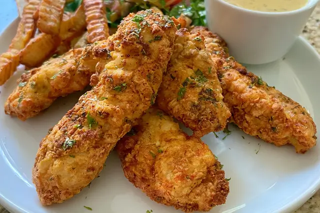 Crispy air fryer chicken tenders coated in seasoned flour, paprika, and herbs