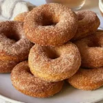 Warm homemade baked apple cider donuts coated in a spiced cinnamon sugar topping.