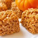 Festive pumpkin rice krispie treats shaped like little pumpkins with pretzel stems.