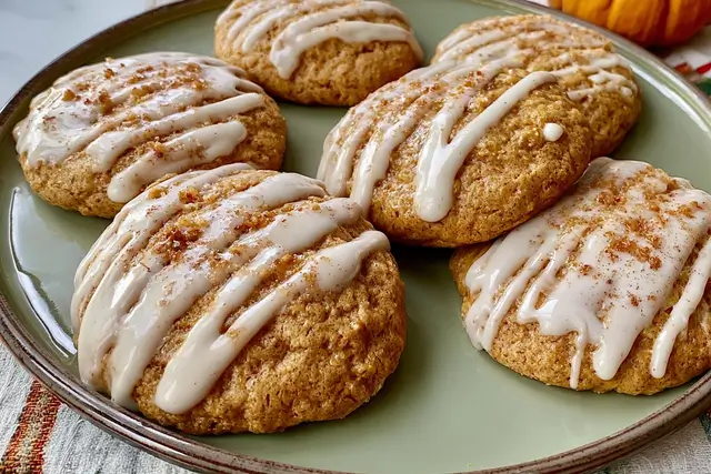 Soft baked iced pumpkin cookies drizzled with a sweet vanilla glaze.
