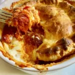 Pizza pot pie with sausage, peppers, onions, mushrooms, sauce, and golden crescent dough