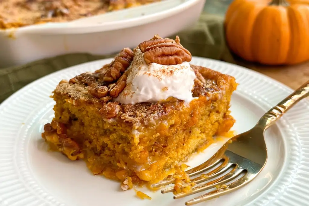 Baked pumpkin dump cake with spice cake mix, melted butter, and chopped pecans.
