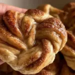 Freshly Baked Sourdough Cinnamon Knots on a Rustic Wooden Board
